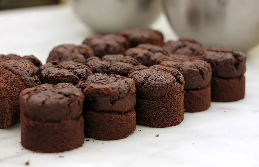 Des petits soufflés au chocolat alignés sur un plan de travail clair