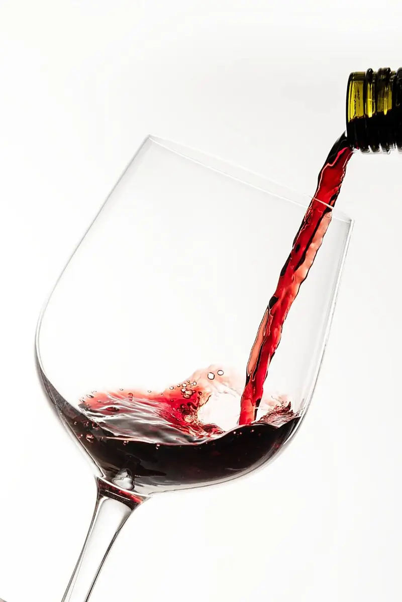Du vin rouge versé dans un verre à pied